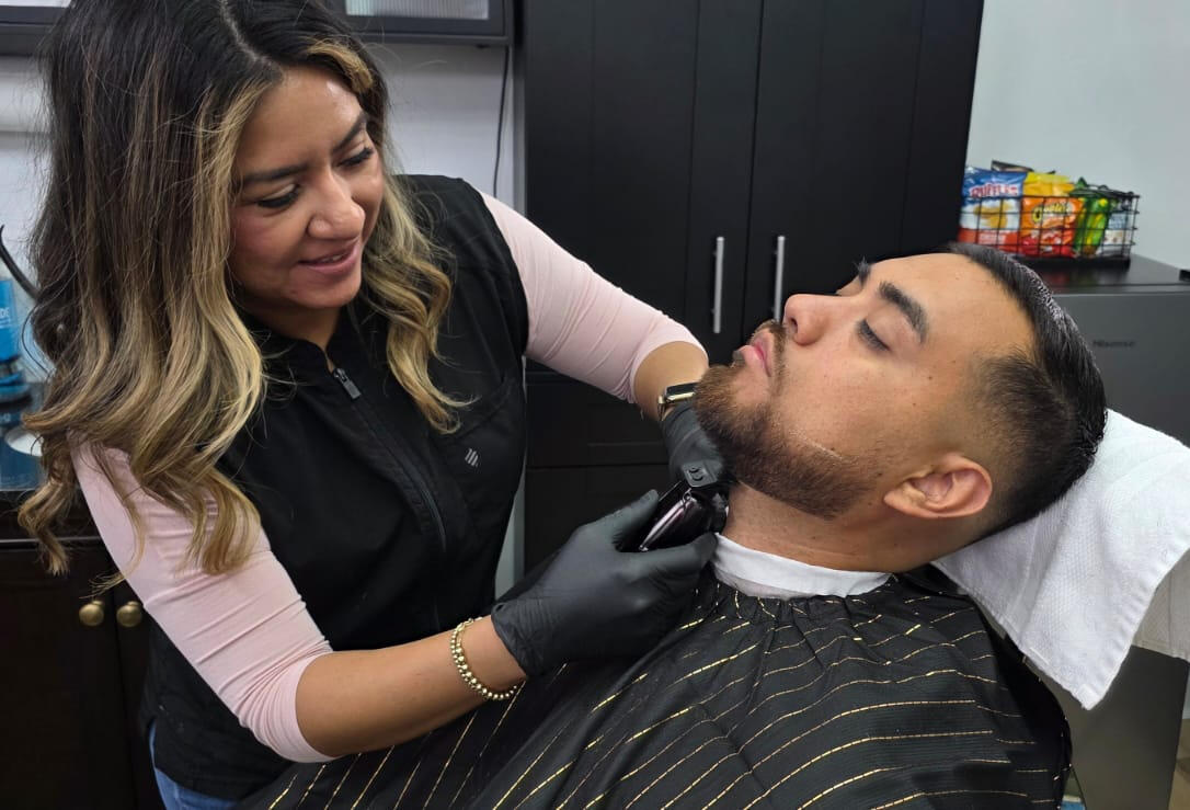 Barber trimming beard